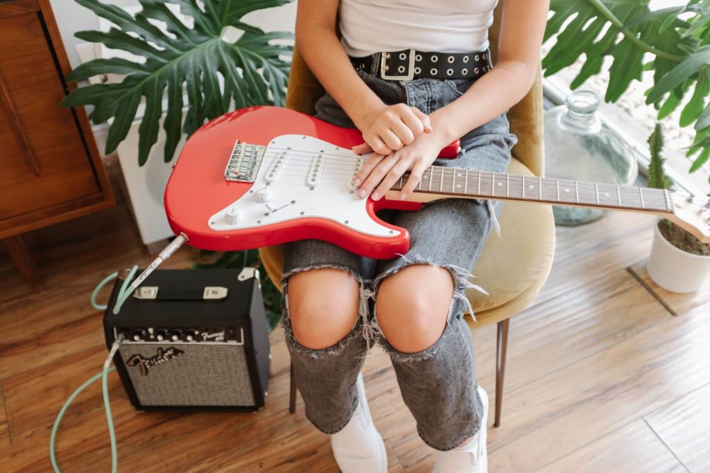 Kind mit E-Gitarre und Verstärker